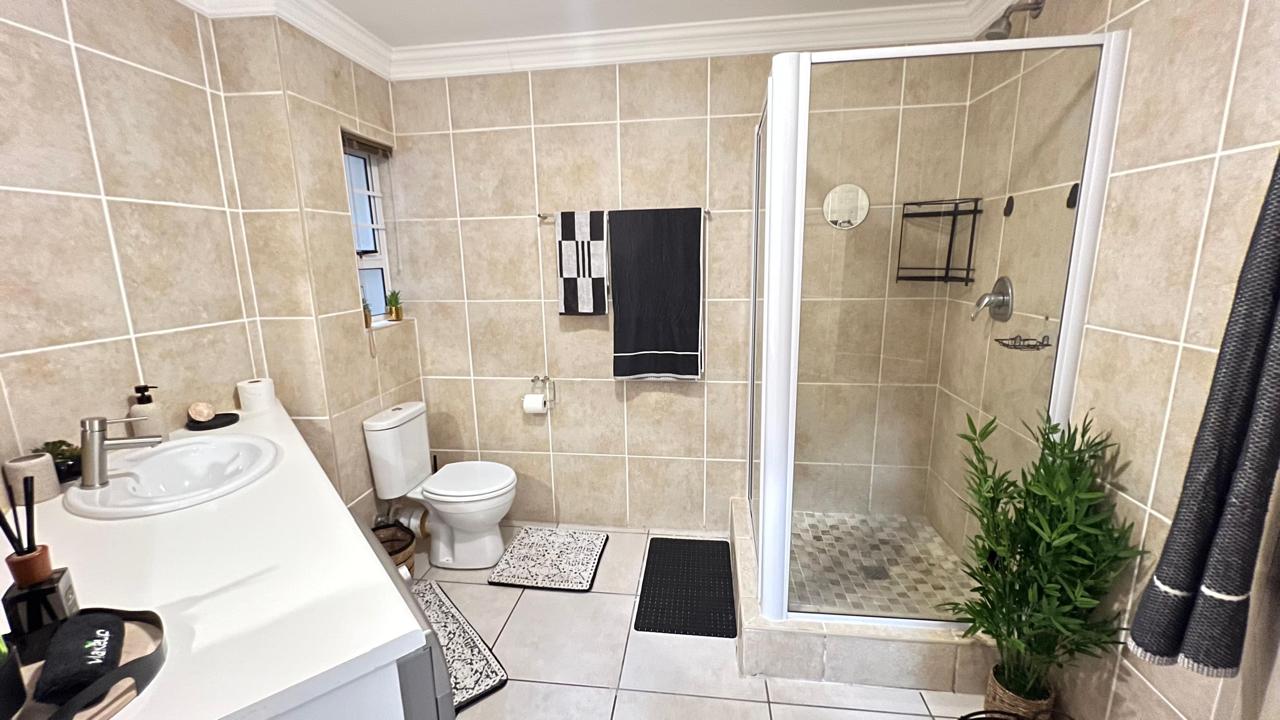 Tiled bathroom with walk-in shower and double basin vanity