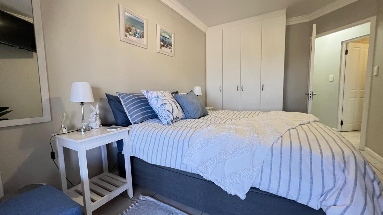 Double bedroom with coastal blue accents and white bedside tables
